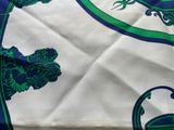a close up of a blue and green scarf with a lizard on it