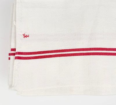 un gros plan d'une serviette rouge et blanche posée sur une surface blanche