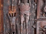 a wooden sculpture of a man and a woman on a shelf