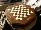 a chess board sitting on top of a wooden table