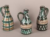 three green and white vases sitting next to each other on a table