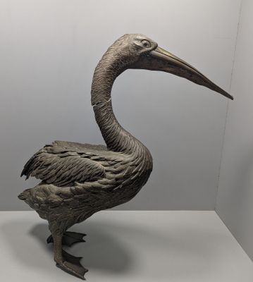statue d'un pélican posé sur une surface blanche dans une pièce blanche