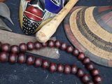a wooden bead necklace with beads and a mask on it