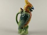 un perroquet en céramique posé sur une tasse verte