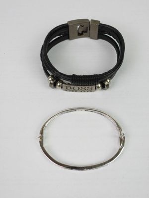 a close up of two bracelets and a ring on a white surface