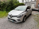 La voiture argentée est garée devant une maison au bord de la route.