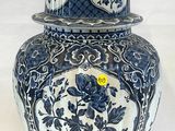 un vase bleu et blanc surmonté d'un chat