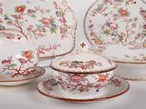 several pieces of china are sitting on a table with a white background