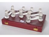 six figurines en verre transparent posées sur un socle en bois rouge