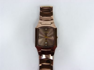 une image d'un gros plan d'une montre-bracelet sur une surface blanche