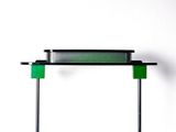 a green lamp that is on top of a black stand