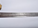 a close up of a sword with a wooden handle