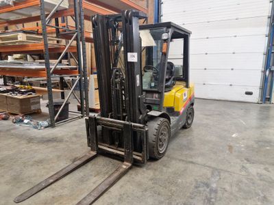 un chariot élévateur dans un entrepôt avec des palettes à l'arrière-plan