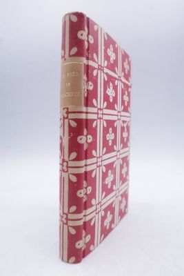 un vieux livre rouge et blanc posé sur une surface blanche