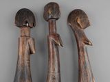 three wooden figurines of a man and a woman