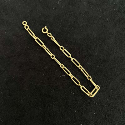 a close up of a gold plated chain on a black surface