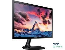 a computer monitor sitting on top of a desk with a mountain in the background