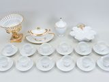 a lot of white and gold dishes and cups and saucers