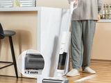 the woman is cleaning the floor with a vacuum and a broom