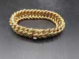 a gold bracelet on a black surface