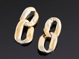 une paire de boucles d'oreilles en or sur une surface noire
