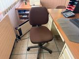 a desk with a chair and a computer on it