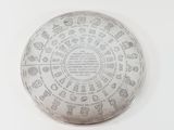 a silver plate with a design on it on a white surface