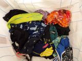 a pile of clothes that is laying on a bed