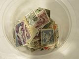 a glass bowl filled with postage stamps on a table