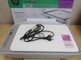 a white hp printer sitting on top of a wooden table next to a box