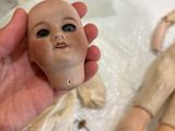 a person holding a doll in their hand next to a doll