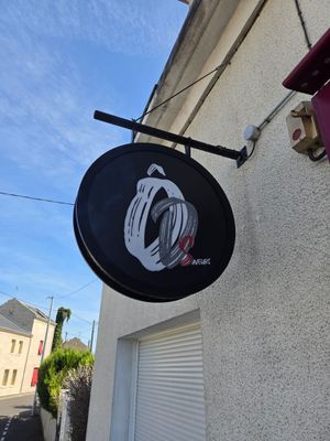 une enseigne accrochée sur le mur d'un immeuble, face à la rue