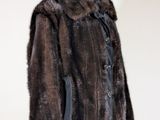 brown fur coat on a mannequin stand against a white wall