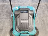 a close up of a blue and black sweepr on a concrete floor