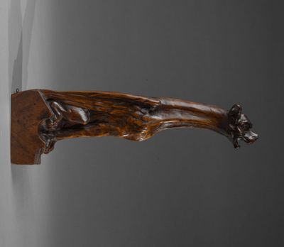un gros plan d'un objet en bois accroché au mur près d'une fenêtre