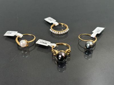 trois paires de bagues en perles et en or sur un fond noir