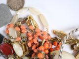 a pile of assorted jewelry on a white surface
