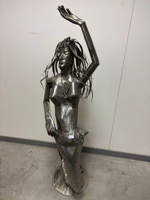 statue of a woman with long hair holding her hands up in the air