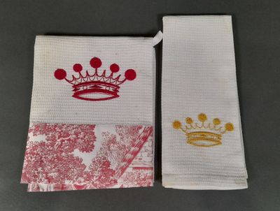 Deux serviettes ornées de couronnes sont posées sur une table