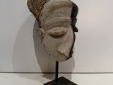 sculpture of a woman ' s head on a stand against a white wall