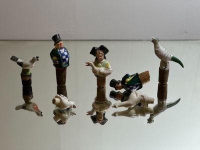 five figurines of people and animals on a glass table