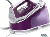 une photo d'un fer à repasser à vapeur violet et blanc posé sur une table