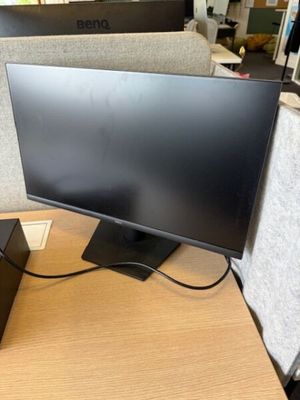un écran d'ordinateur posé sur un bureau dans un box de bureau