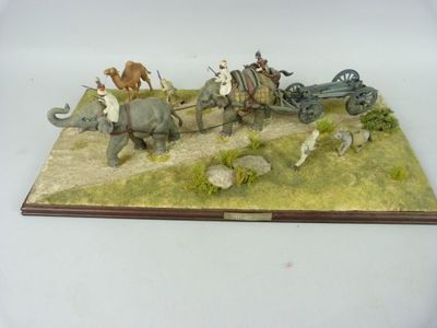 figurine représentant un groupe de personnes chevauchant des éléphants et tirant une charrette