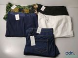 three pairs of jeans with tags on them sitting on a table