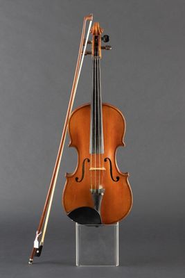 an old violin with a bow and bow rest on a stand