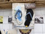 a picture of a sign with a pair of flip flops on it