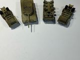 four small army vehicles sitting on a white surface