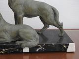 two statues of a dog and a horse on a marble base