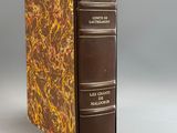 an old book sitting on top of a white table next to a gray wall